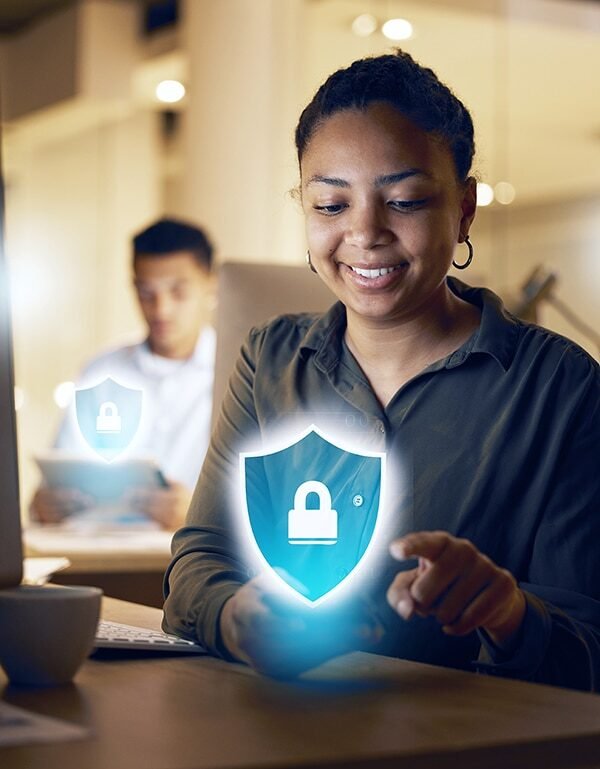 A woman in an office interacts with holographic SSL Cert shields, symbolizing digital protection, with a male colleague in the background.